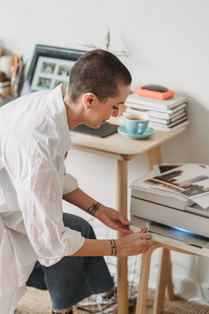 The Art of Drawing Readers In: Your attractive post title goes here High angle of female with short hair sitting near laptop and cup of coffee and printing photos